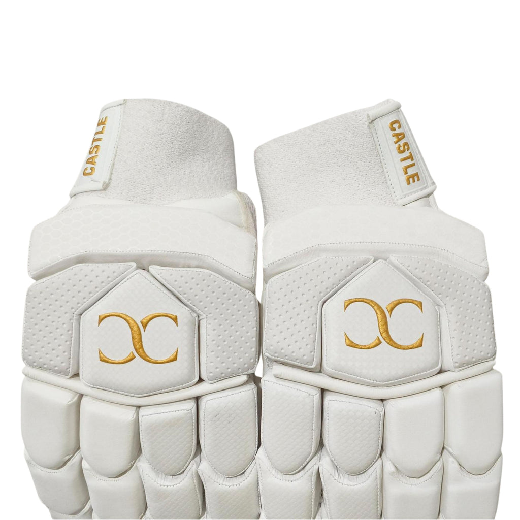 Castle white and gold batting gloves showing wrist cuffs and back-of-hand padding
